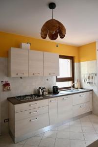 a kitchen with white cabinets and a stove top oven at Maison Josephine in Chiusa di Pesio