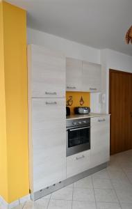 a kitchen with white cabinets and a stove at Maison Josephine in Chiusa di Pesio +25 photos