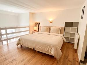 a bedroom with a large bed and a wooden floor at Large 2 bedrooms Duplex - City Center & free Parking in Arcachon