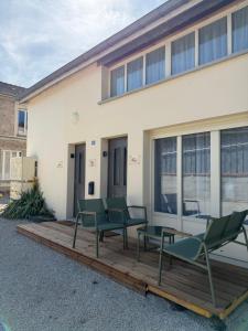 a deck with green chairs and a building at La Belle Prise in Matougues