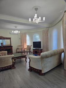 a living room with a couch and a tv at Bilgah Garden Villa in Bilgah