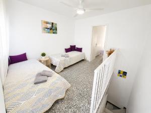 a white room with two beds and a couch at CASA EN EL CENTRO HISTORICO in Nerja