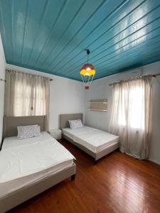 two beds in a room with a blue ceiling at Para Thin Alos Skiathos in Skiathos