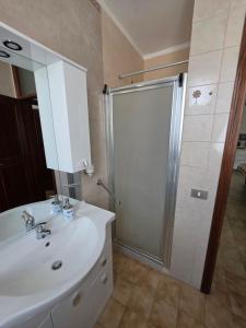 a bathroom with a white sink and a shower at Appartamento Pullino in Marina di Ravenna +4 photos