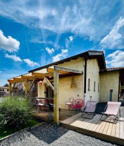 a house with a deck with chairs and tables at La bohème, gîte de charme in Quincié-en-Beaujolais