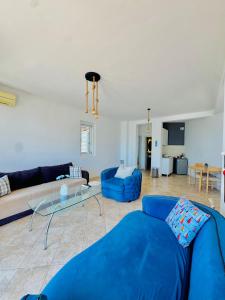 a living room with a blue couch and a glass table at Budva Sky Sea - View Point in Budva