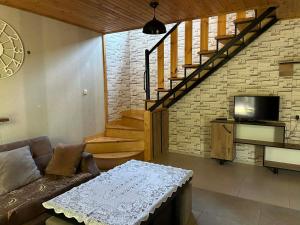 a living room with a couch and a staircase at Levani's Cottage in Borjomi