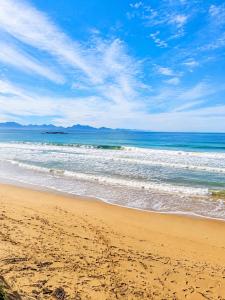 a sandy beach with waves in the ocean at Diaz De Valle 35 in Mossel Bay