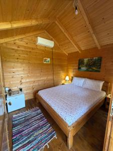a bedroom with a bed in a wooden cabin at Camp Sunny Hills in Virpazar