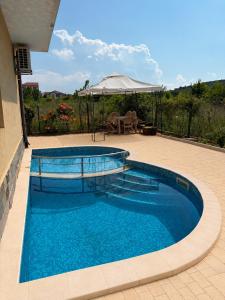 a swimming pool with blue water on a patio at Perla View Apartment in Primorsko