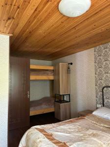 a bedroom with two bunk beds and a wooden ceiling at Levani's Cottage in Borjomi