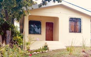 a small white house with a red door at Casa Malu in Morote