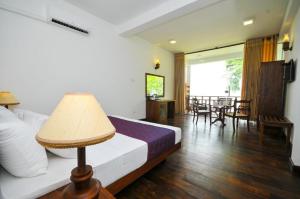 a bedroom with a bed and a table with chairs at Peacock Wild YALA in Tissamaharama +27 photos