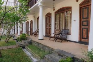a porch of a house with rocking chairs at Peacock Wild YALA in Tissamaharama