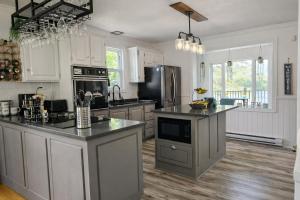 a kitchen with white cabinets and black counter tops at Chalet Cozy Spa sur Lac in Saint-André-Avellin