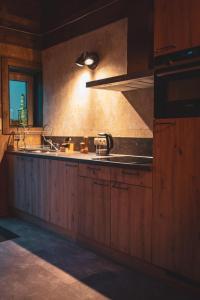 a kitchen with wooden cabinets and a sink at Atelier 69 Loveroom in Paliseul +5 photos