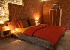 a bedroom with a bed with a red comforter at Atelier 69 Loveroom in Paliseul