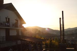 a house with the sunset in the background at Князів Двір in Bukovel