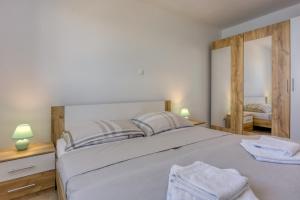 a bedroom with a large bed with two mirrors at 2Bfree Apartments in Stinica +103 photos