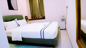 a bedroom with a white bed with a green headboard at Greenland HomeINN in Kigali +15 photos