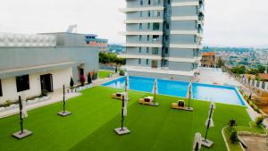 a building with a swimming pool and a green lawn at Greenland HomeINN in Kigali