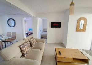 a living room with a couch and a tv on a wall at Cozy South in Mahébourg