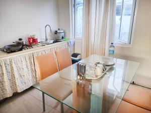 a glass table and chairs in a kitchen with a counter at Cozy South in Mahébourg