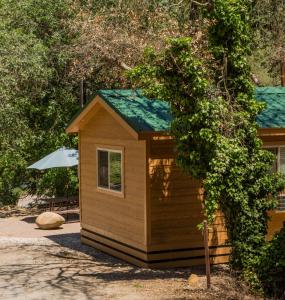 a small wooden cabin with a green roof at Ponderosa Camping Resort One-Bedroom Cabin 4 in Lotus