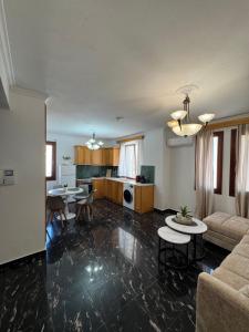 a living room with two tables and a kitchen at Almeta Apartments Port in Chios