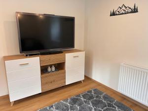 a flat screen tv sitting on top of a white entertainment center at MyAlpenloft 2 in Deutschgriffen