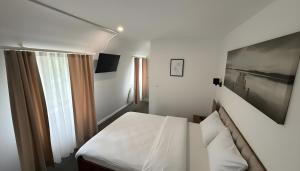a small bedroom with a bed and a window at Hotel am Kocher in Schwäbisch Hall