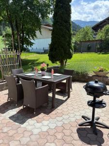 a patio table and chairs with a bbq grill at Apartment Tirol #Spielanger Hof# in Weer
