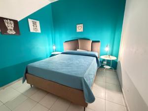 a blue bedroom with a bed with blue walls at TESEO Siracusa in Ortigia fuori dalla ZTL in Syracuse