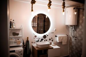 a bathroom with a sink and a mirror at Nexus Apartman in Apatin