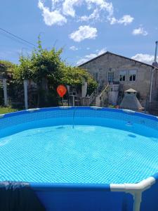 a large blue swimming pool in front of a house at Casa Nodar in Chantada