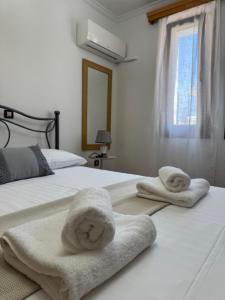 two beds with towels sitting on top of them at Almeta Apartments Port in Chios
