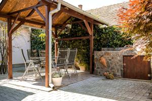 a wooden pergola with chairs and a table on a patio at Nexus Apartman in Apatin