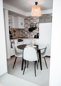 a kitchen and dining room with a table and chairs at Nexus Apartman in Apatin
