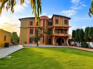 a large house with a green lawn in front of it at Lila Palace in Nepālganj