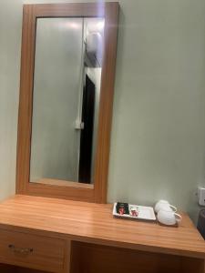 a mirror on top of a wooden dresser in a room at Lila Palace in Nepālganj