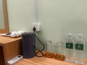 a counter with bottles of water and a charger at Lila Palace in Nepālganj
