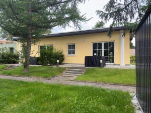 a yellow house with a table in the yard at Casa Mia 37 am See in Joachimsthal