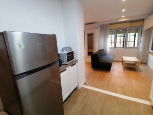 a kitchen with a refrigerator and a living room at Apartamentos Almenada in Llanes