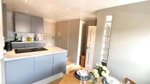 a kitchen with white cabinets and a wooden table at Cozy nest- walking distance to city center in Bergen +9 photos