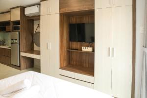 a kitchen with white cabinets and a tv in it at AN Studio VVT in Ho Chi Minh City