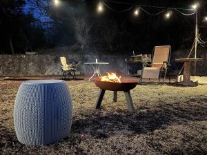 a fire pit sitting in the yard at night at Big Island Base 一組限定の庭付き一棟貸し BBQ 焚き火 テントサウナ 最大6名 in Oshima