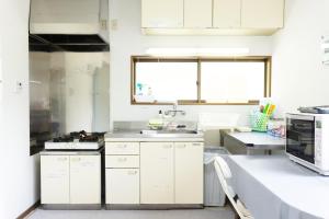 a kitchen with white cabinets and a sink at Big Island Base 一組限定の庭付き一棟貸し BBQ 焚き火 テントサウナ 最大6名 in Oshima