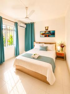 a bedroom with a large bed with blue curtains at Pointe D'Esny Villa 1 in Mahébourg