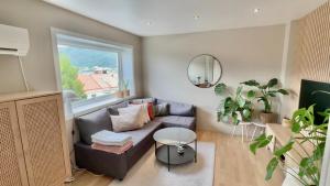 a living room with a couch and a large window at Cozy nest- walking distance to city center in Bergen