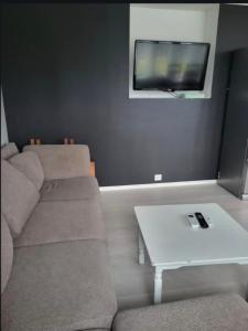 a living room with a couch and a tv on a wall at Sentral leilegheit i Ørsta in Ørsta +13 photos